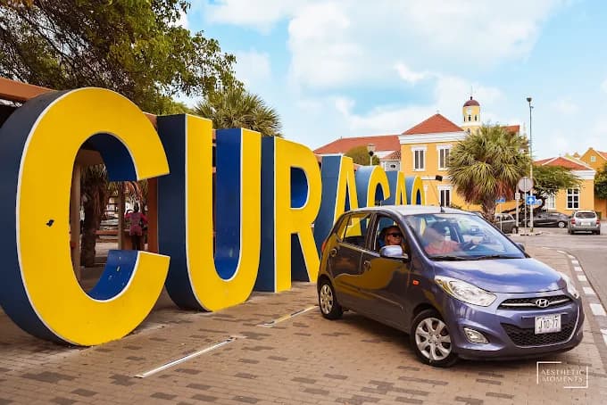 Huurauto bij het gekleurde CURAÇAO-bord in Willemstad
